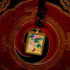 Hand holding lotus Ghau Thangka locket with hand-painted symbolic artwork inside traditional Himalayan amulet Nepal